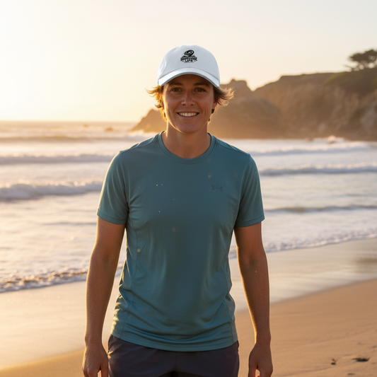 Woman wearing HLSC white performance cap outdoors at golden hour